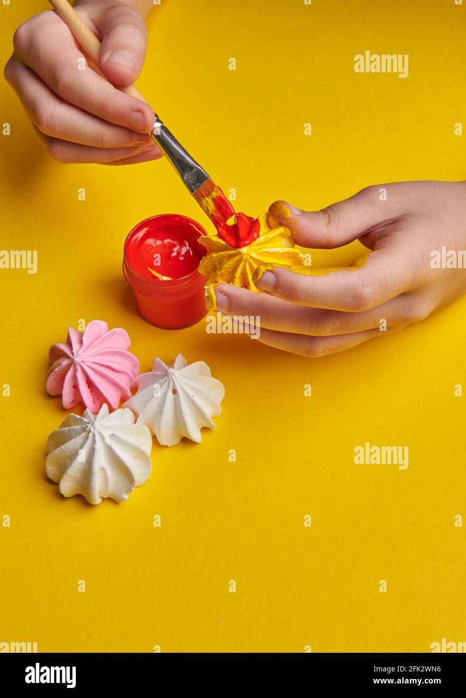 brush with paints on a yellow background Stock Photo
