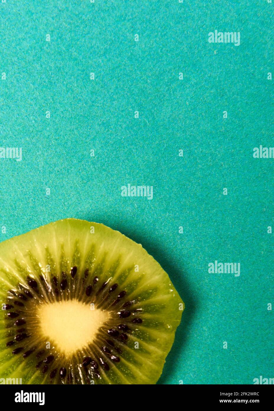 kiwi slice on a blue background lies Stock Photo