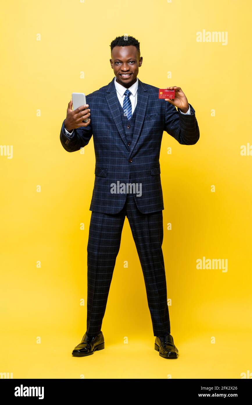 Smiling young African man in business suit showing credit card while ...