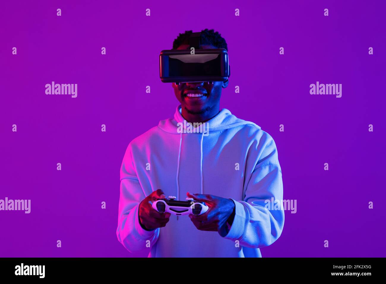 Young African man wearing VR glass headset playing game with joystick ...