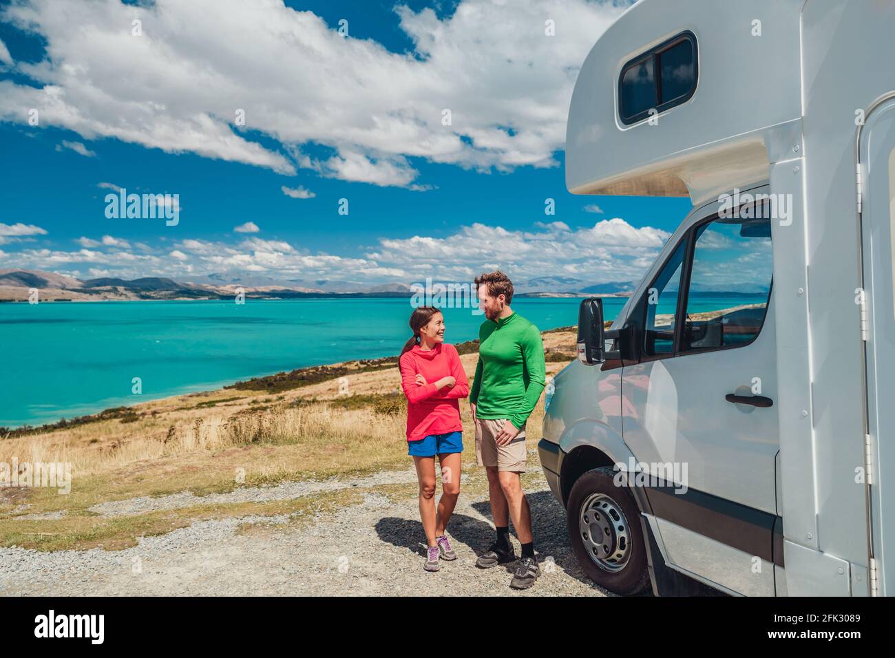 RV motorhome camper van road trip on New Zealand. Young couple on travel vacation adventure. Two tourists looking at Lake Pukaki and mountains on pit Stock Photo