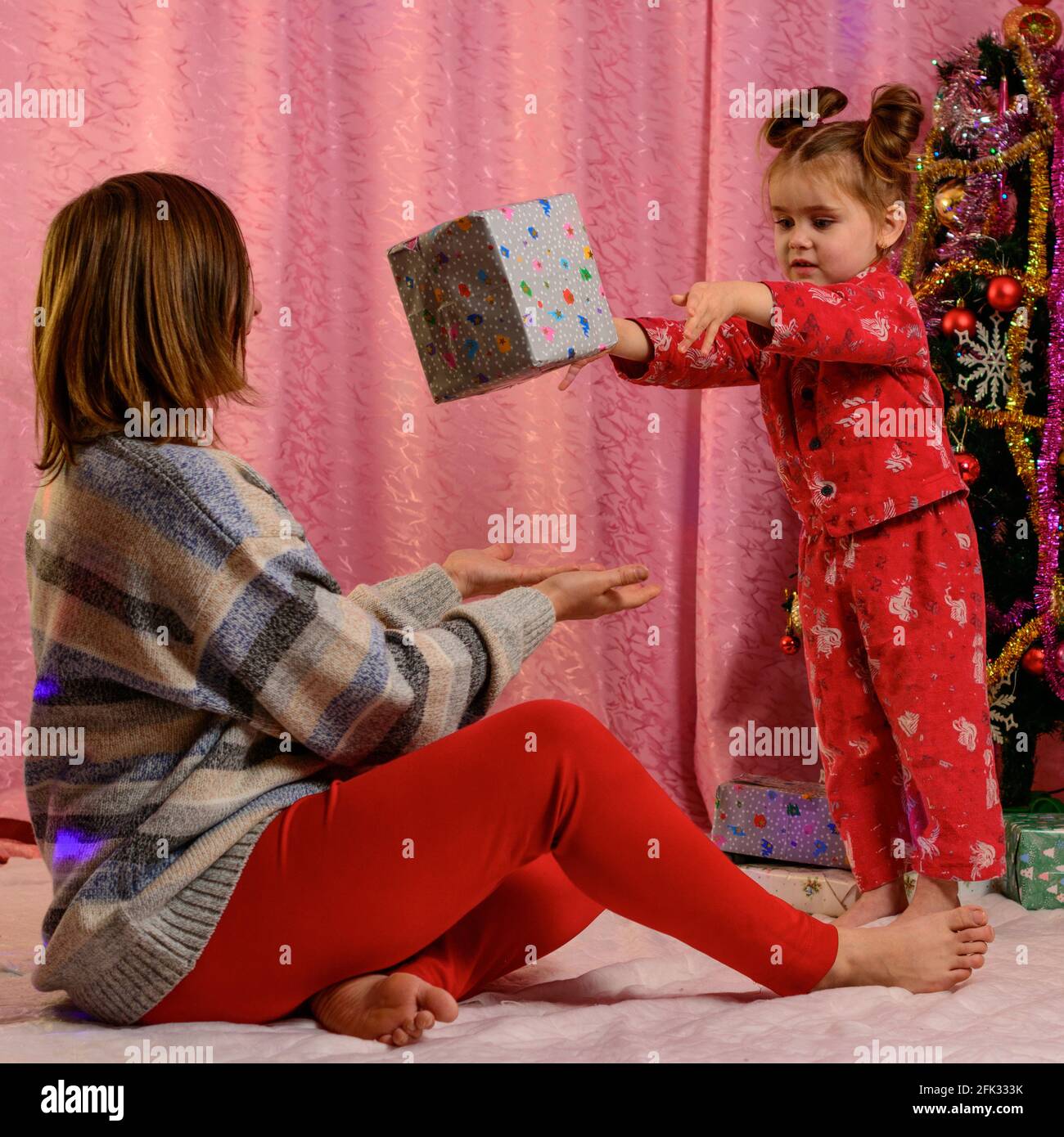 Christmas and New Year gifts, mom and daughter with gifts at home near