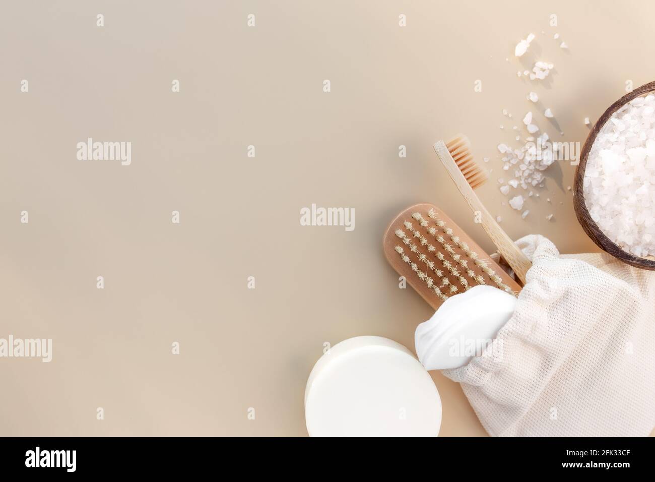 Bath accessories flat lay on beige background. Natural body care components. Healthcare concept, wooden tooth brush, foot brush, cotton pads, soap. Ec Stock Photo