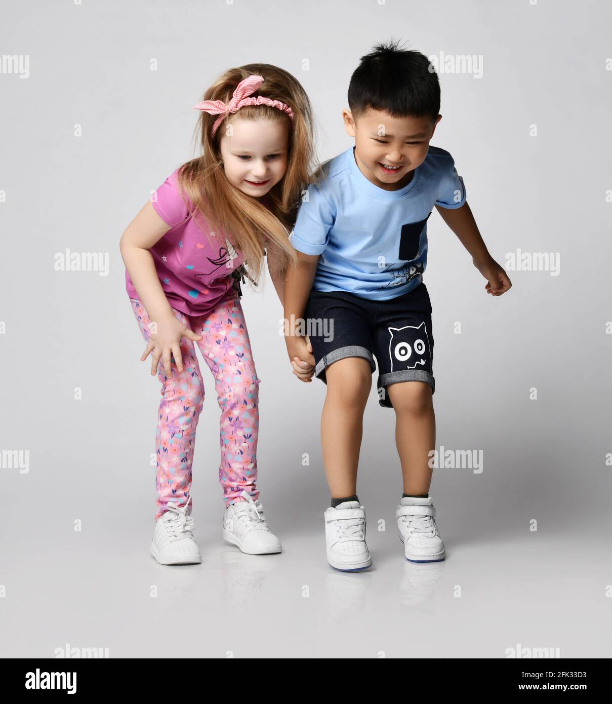 Two Active Frolic Kids Friends Boy And Girl In Summer Clothes Stand Together Looking Down Noticed Something On Floor Stock Photo Alamy