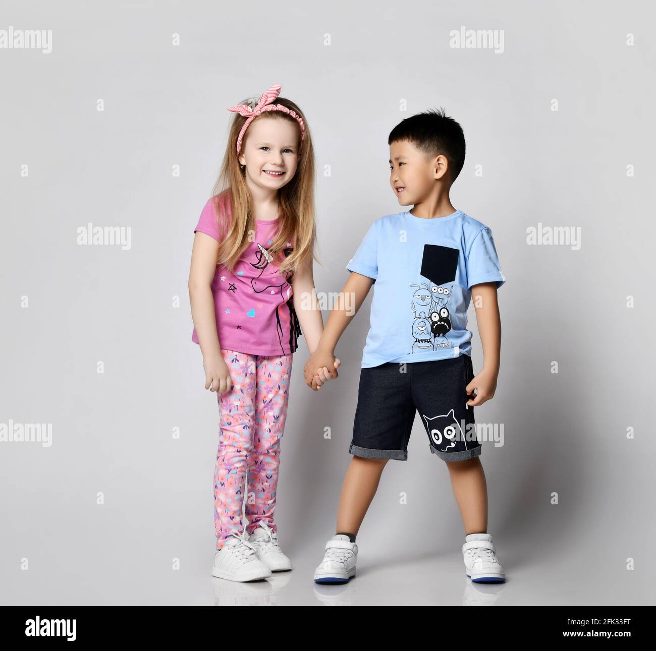 Two cheerful kids friends Asian boy and Caucasian girl have good time ...