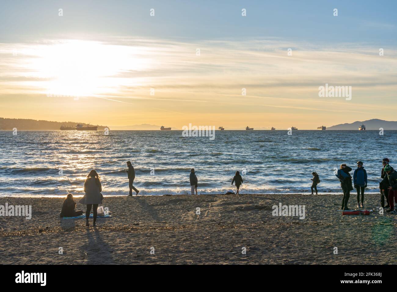 People enjoy the sunset at English Bay Beach, Vancouver City beautiful nature landscape. Vancouver, BC, Canada. Stock Photo