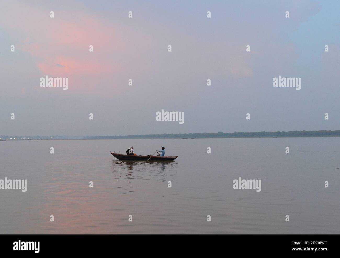 Pilgrims riding a boat on the Ganges river in Varanasi. Stock Photo