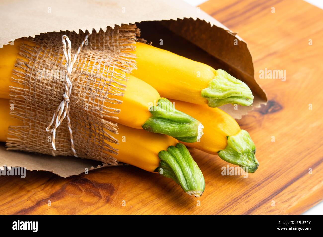 Summer Squash Zucchini, Yellow Colored Gourd Also Known As Courgette, Baby Marrow, Indian Jugni Sabzi Or Jugnu Petha Sabji Tied In Jute Cloth And Pack Stock Photo
