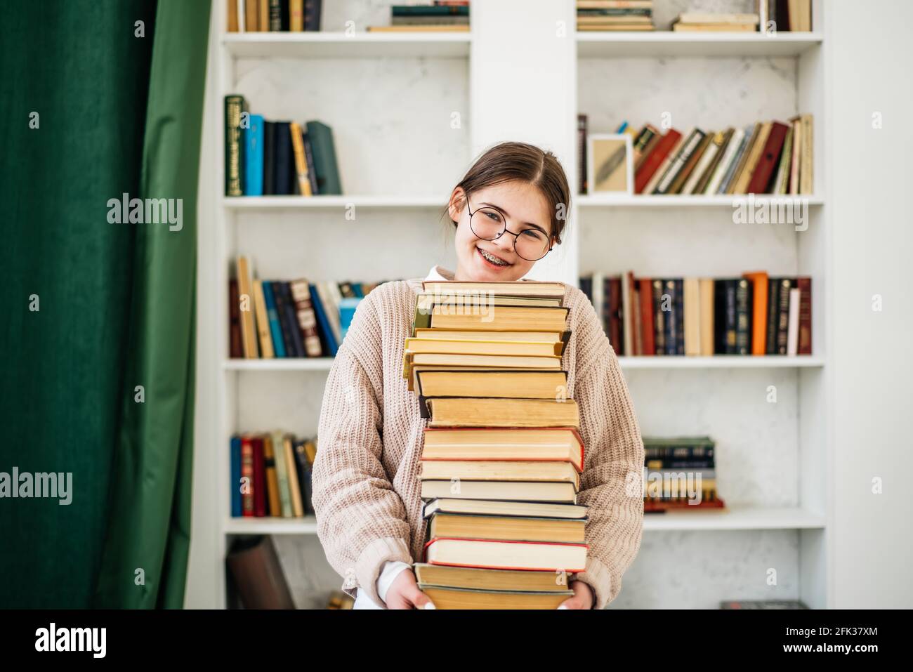 Young girl standing near the bookshelf in library Stock Photo - Alamy