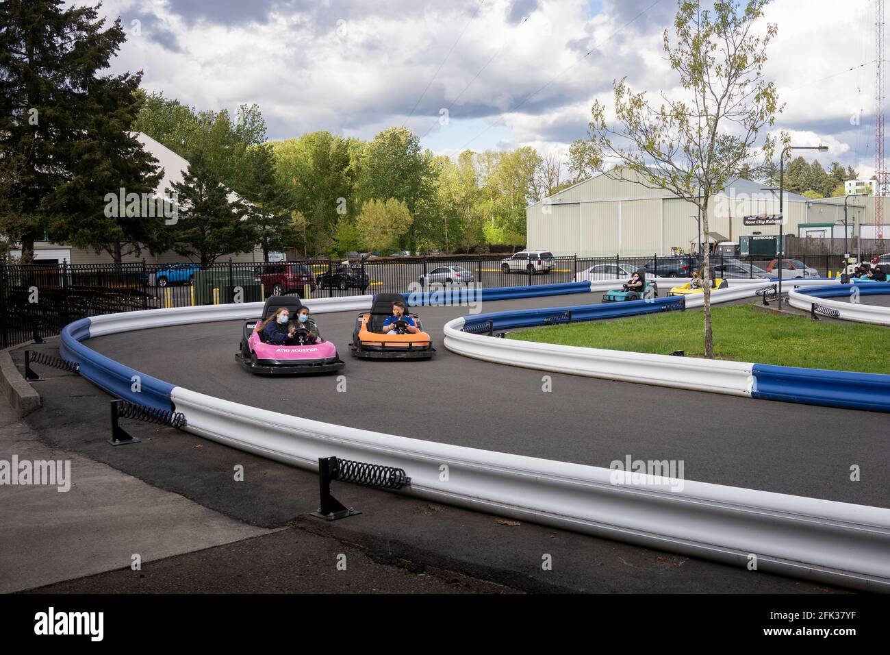 Masked visitors kart racing in Portland's Oaks Amusement Park that reopens in compliance with COVID mandates on Sunday, April 25, 2021, amid the pandemic. Stock Photo