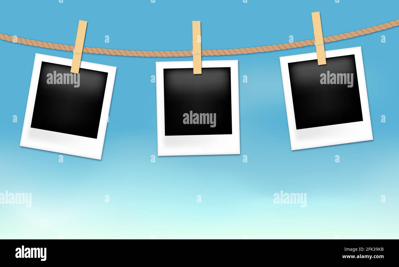 Photo frames hanging on the rope with wood pins on sky background Stock