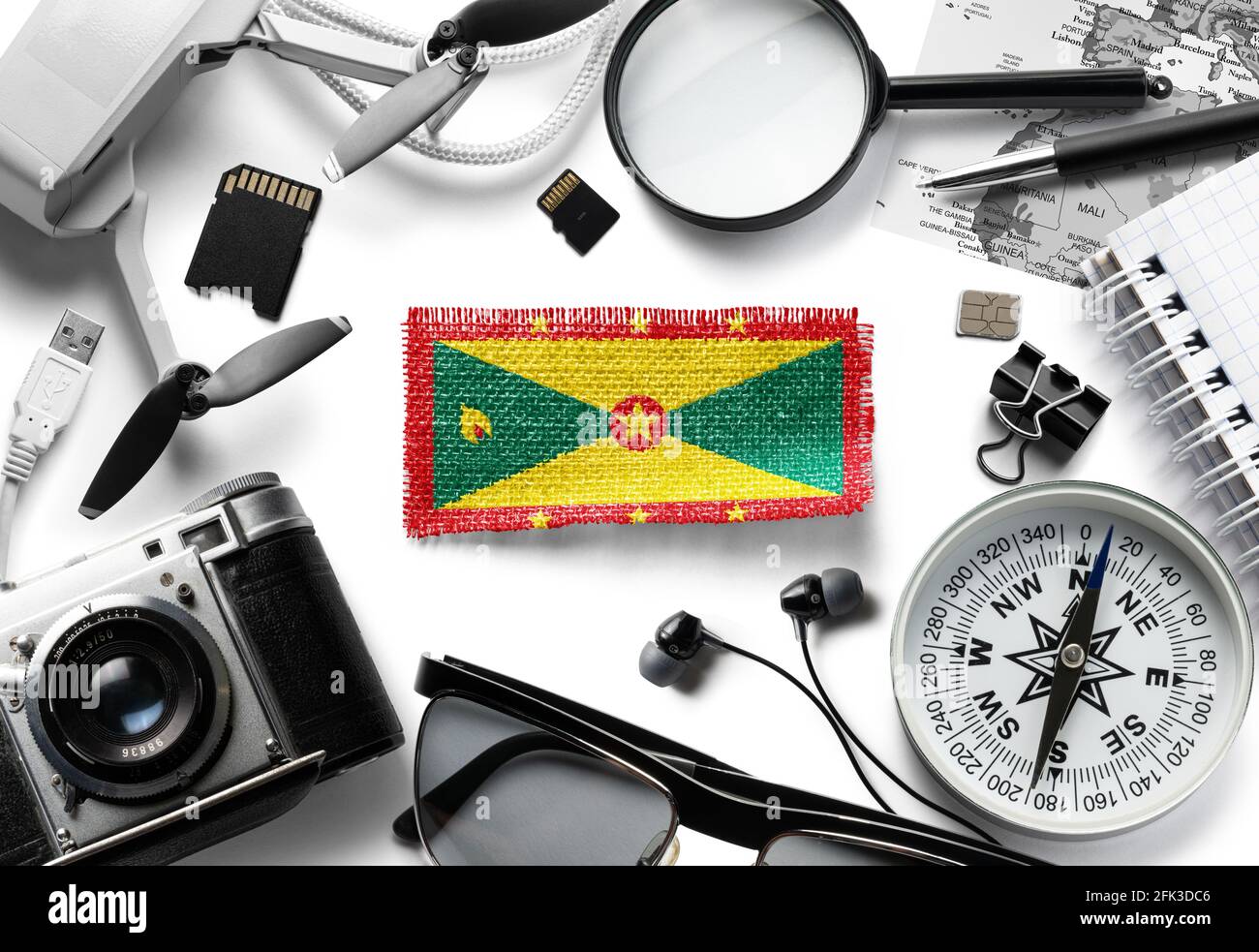 Flag of Grenada and travel accessories on a white background. Stock Photo