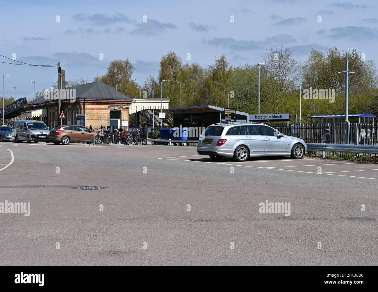 Car park and station buildings at MoretoninMarsh train station in Gloucestershire Stock Photo
