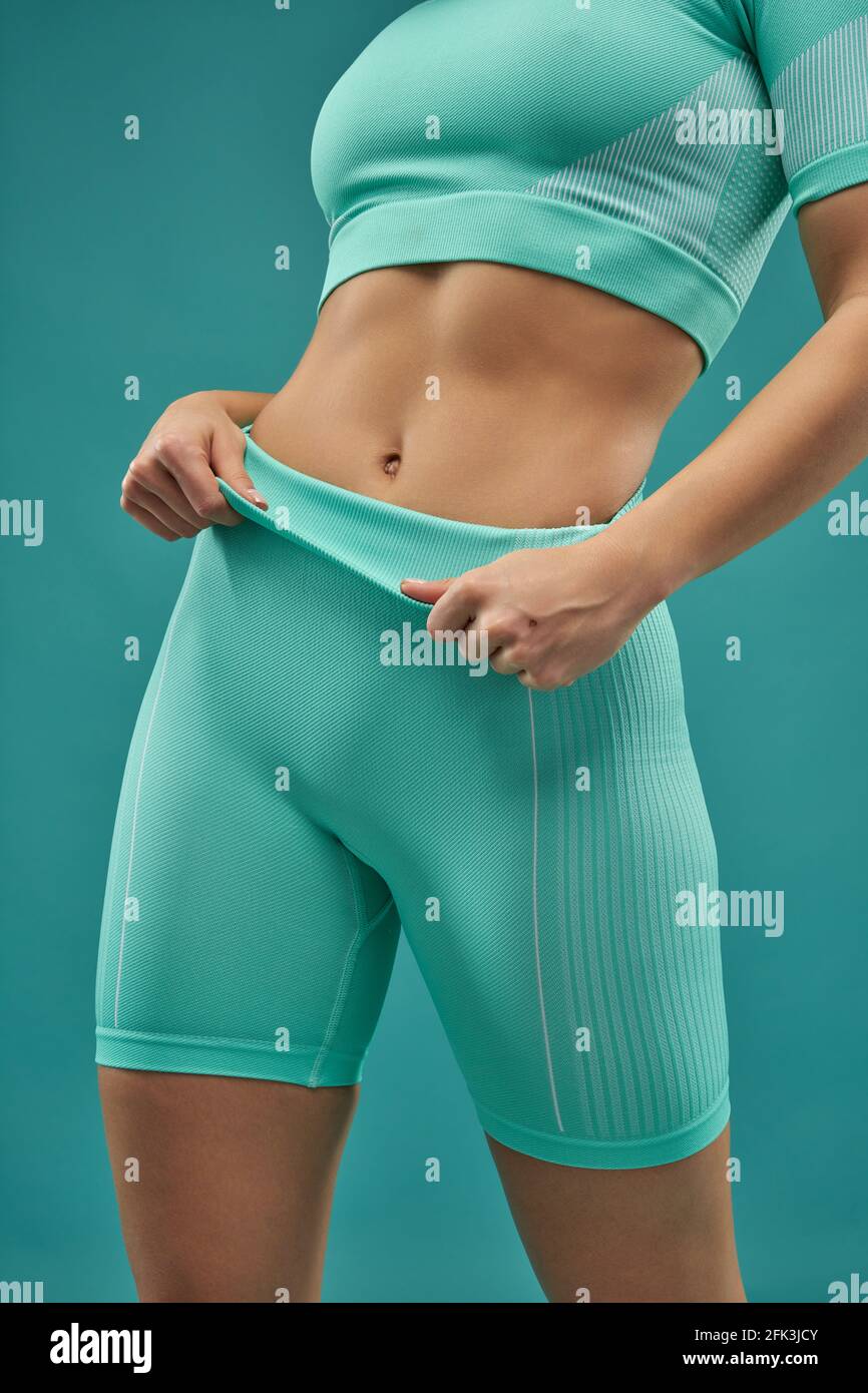 Sporty young woman demonstrating her perfect flat stomach Stock Photo