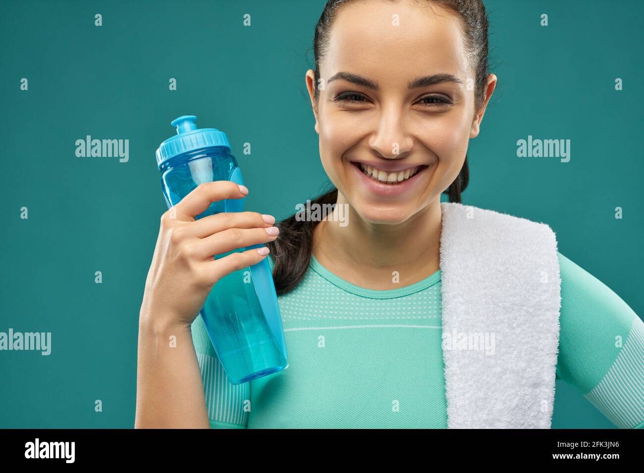 Cheerful young woman holding bottle of water Stock Photo