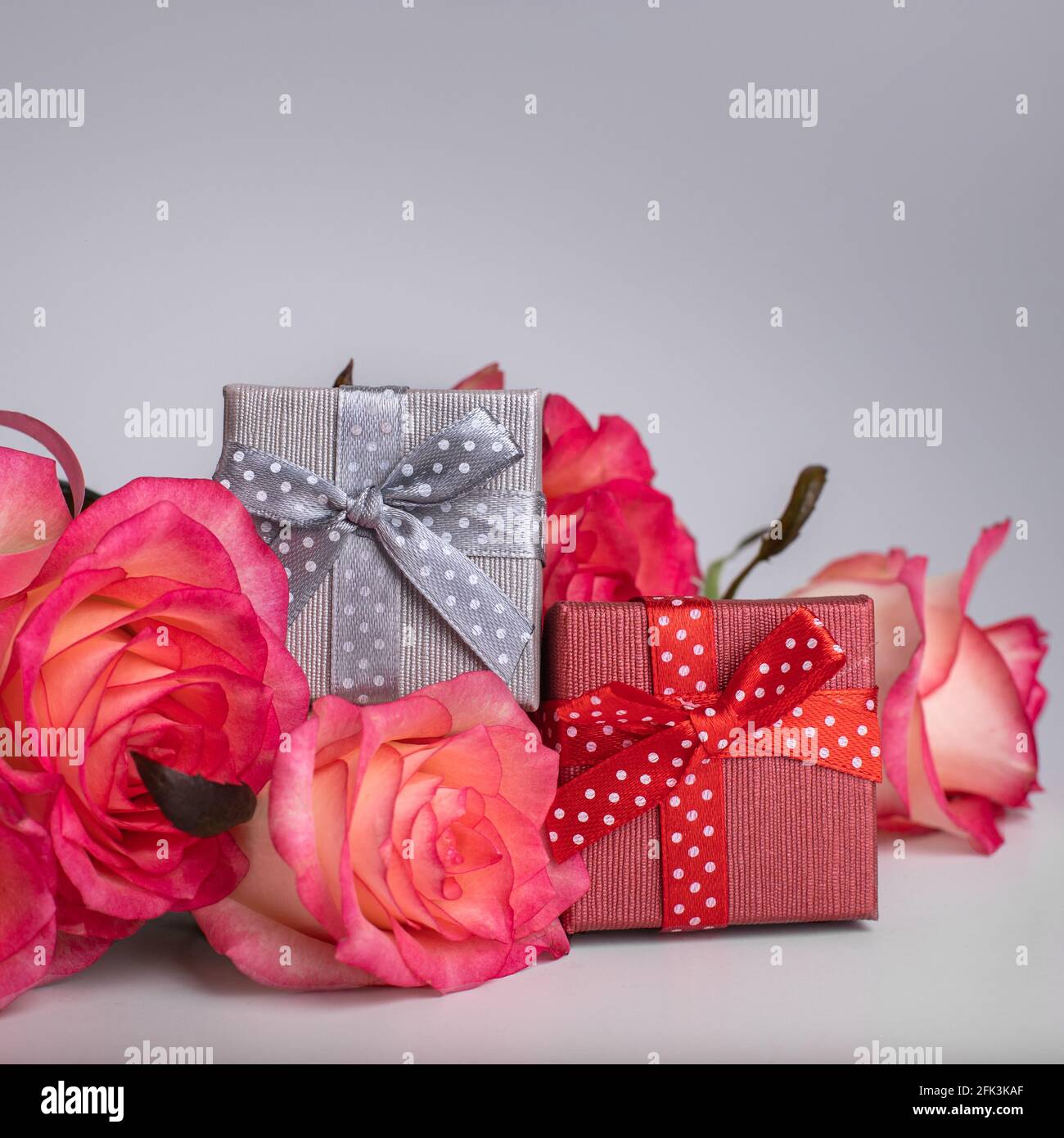 Gift box in silver and red for a jewel and pink roses. Jewelry boxes