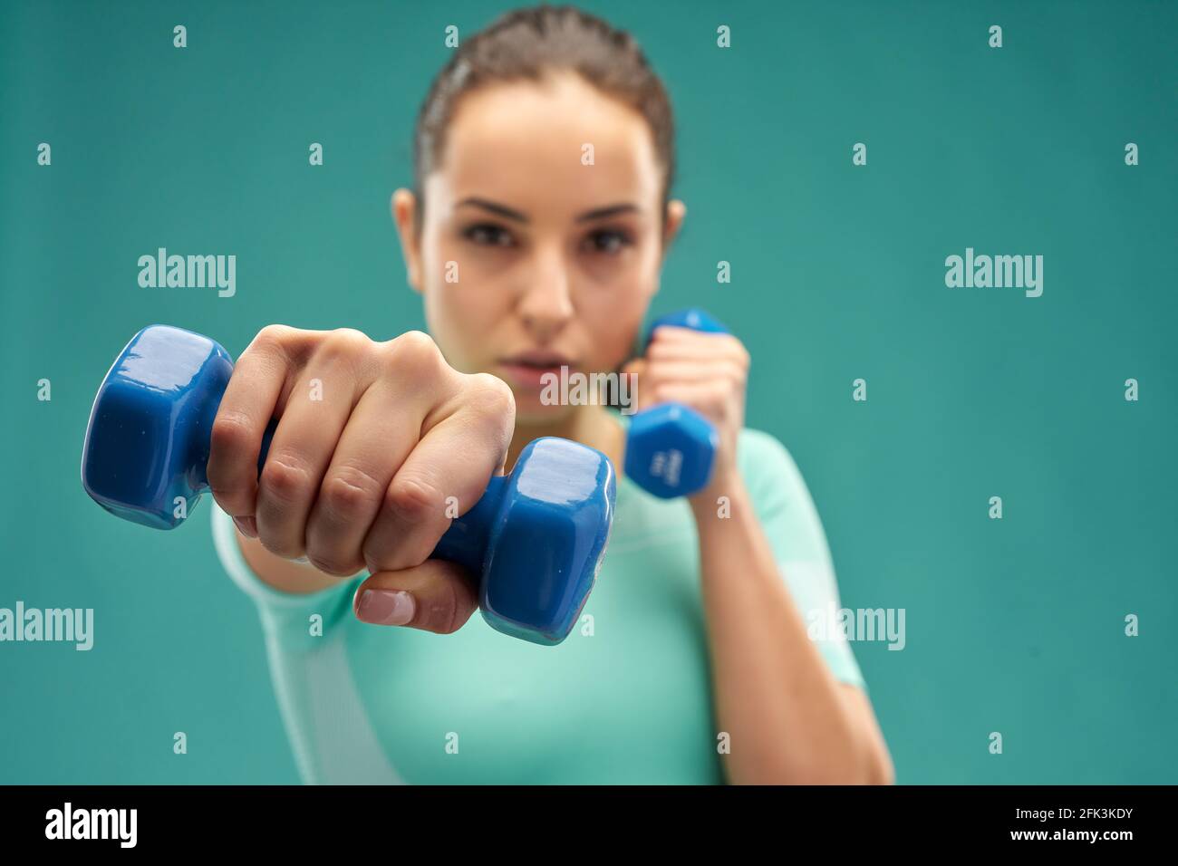 Charming young woman doing exercise with dumbbells Stock Photo