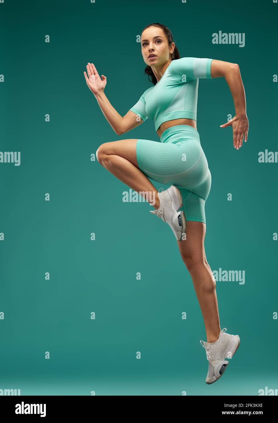 Sporty young woman jumping in the air Stock Photo