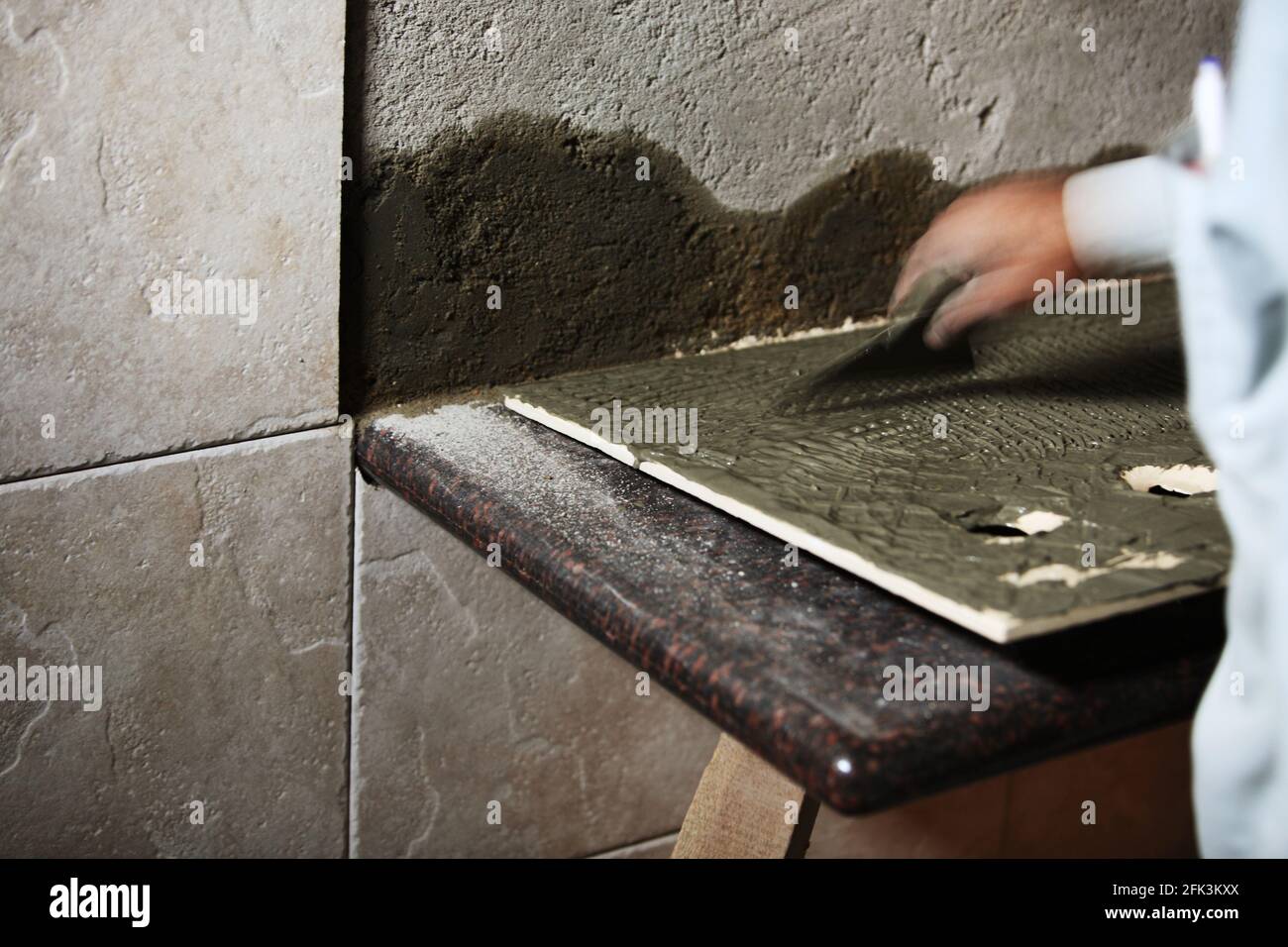 Tile mason pasting tiles on wall with cement Stock Photo Alamy