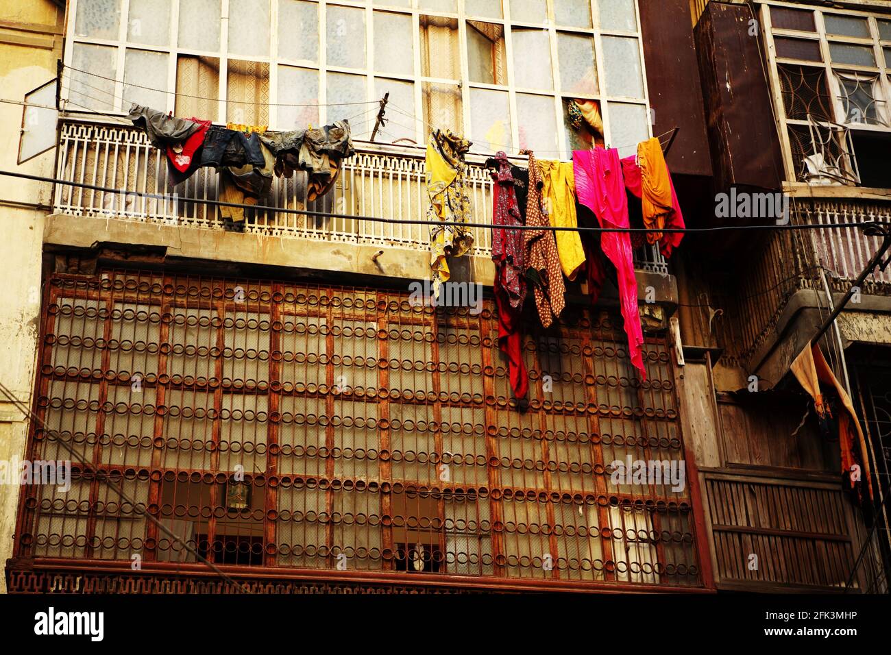 Cloths of women and children are hanging outside balcony of flats in Karachi, Pakistan. Notice the packed windows for the purpose of Purdah. Stock Photo