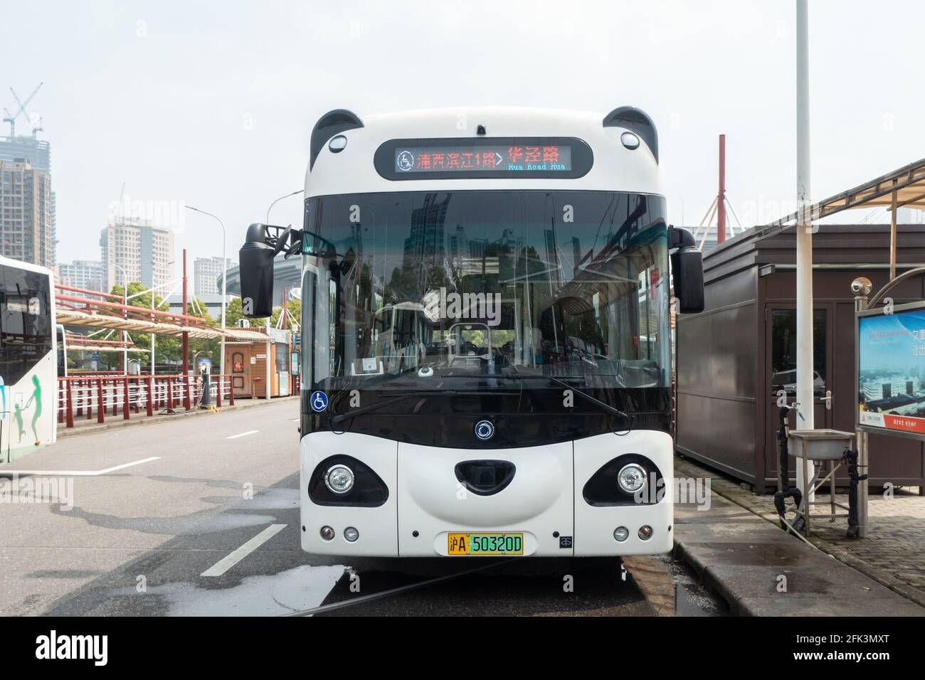 Shanghai, Shanghai, China. 28th Apr, 2021. On April 28, 2021, in Shanghai, at a bus station near the Nanpu Bridge, a staff member is cleaning a cute panda car. On April 27, 4 super cute panda buses were put into operation on Binjiang 1 Road in Puxi, adding a moving landscape along the riverside. The two ''big eyes'' on the front of the panda car not only come with dark circles, but there are actually two round black ''small ears'' on the roof. From a distance, it is a cute cartoon panda. It is reported that the panda bus is a new type of pure electric barrier-free bus. The barrier-free pe Stock Photo