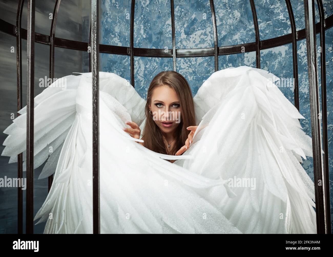 a woman in a cage with angel wings Stock Photo - Alamy