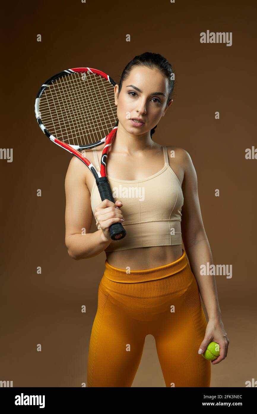 Beautiful young woman holding tennis racket and ball Stock Photo