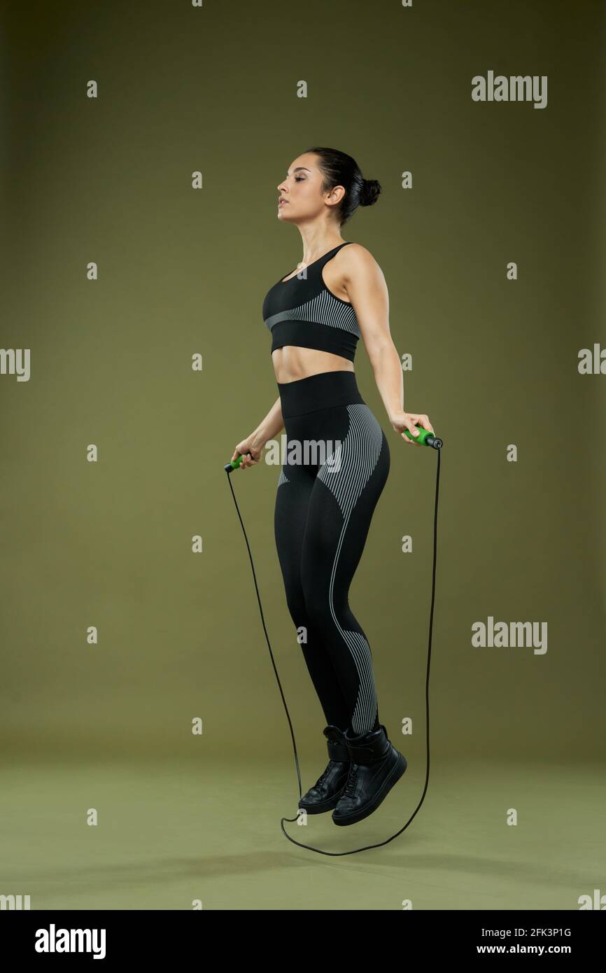 Sporty young woman doing exercise with jump rope Stock Photo