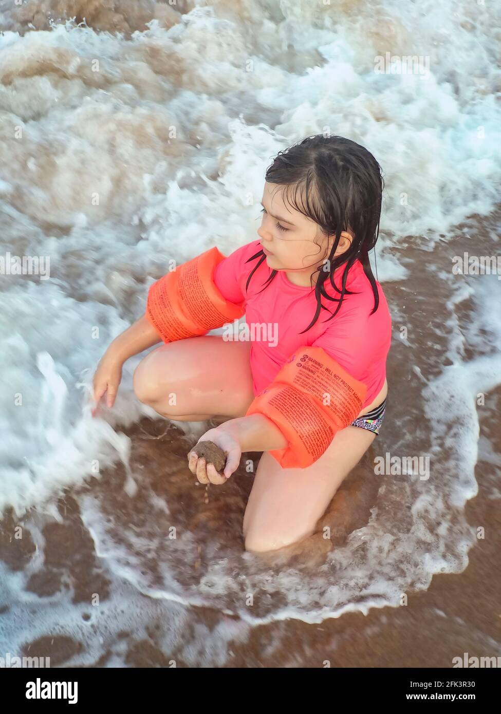 Girl kneeling in the sand hi-res stock photography and images - Alamy