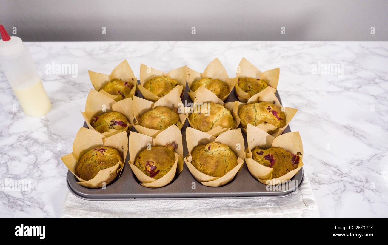 Step by step. Cooling freshly baked cranberry muffins. Stock Photo