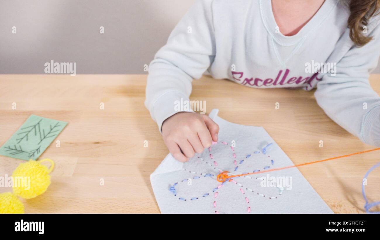 Little girl learning how to sew with sewing craft kit for kids Stock