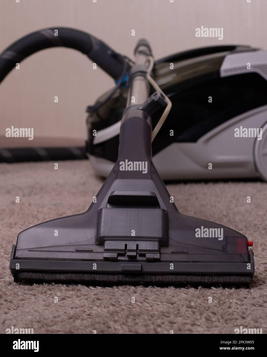 Vacuum cleaner black gray with a carpet cleaner. Washing vacuum cleaner. Cleaning the house.A close up of a toy. Stock Photo