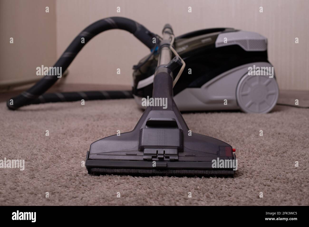 Vacuum cleaner black gray with a carpet cleaner. Washing vacuum cleaner. Cleaning the house.A close up of a toy. Stock Photo