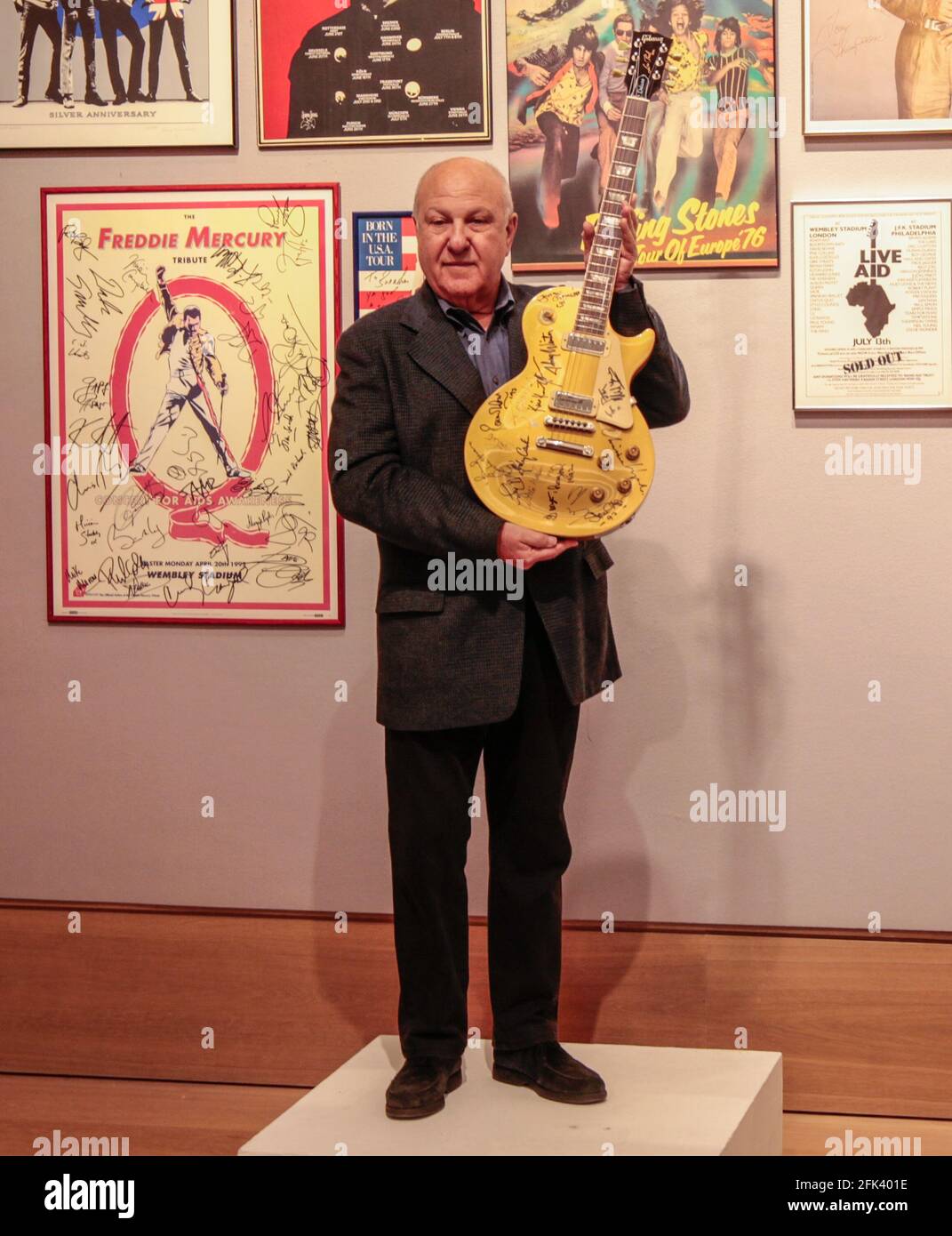 London UK 28 April 2021 Harvey Goldsmith holding the a Les Paul Gold Top Guitar signed at Bob Dylan’s 30th Anniversary Concert by stars there on the night - George Harrison, Eric Clapton, Stevie Wonder and Dylan himself (estimate: £10,000 - 15,000). besides the Fredy Mercury Tribute concert for AIDS multisgned and The Band Aidperonalised for  Harvey Paul Quezada-Neiman/Alamy Live News Stock Photo