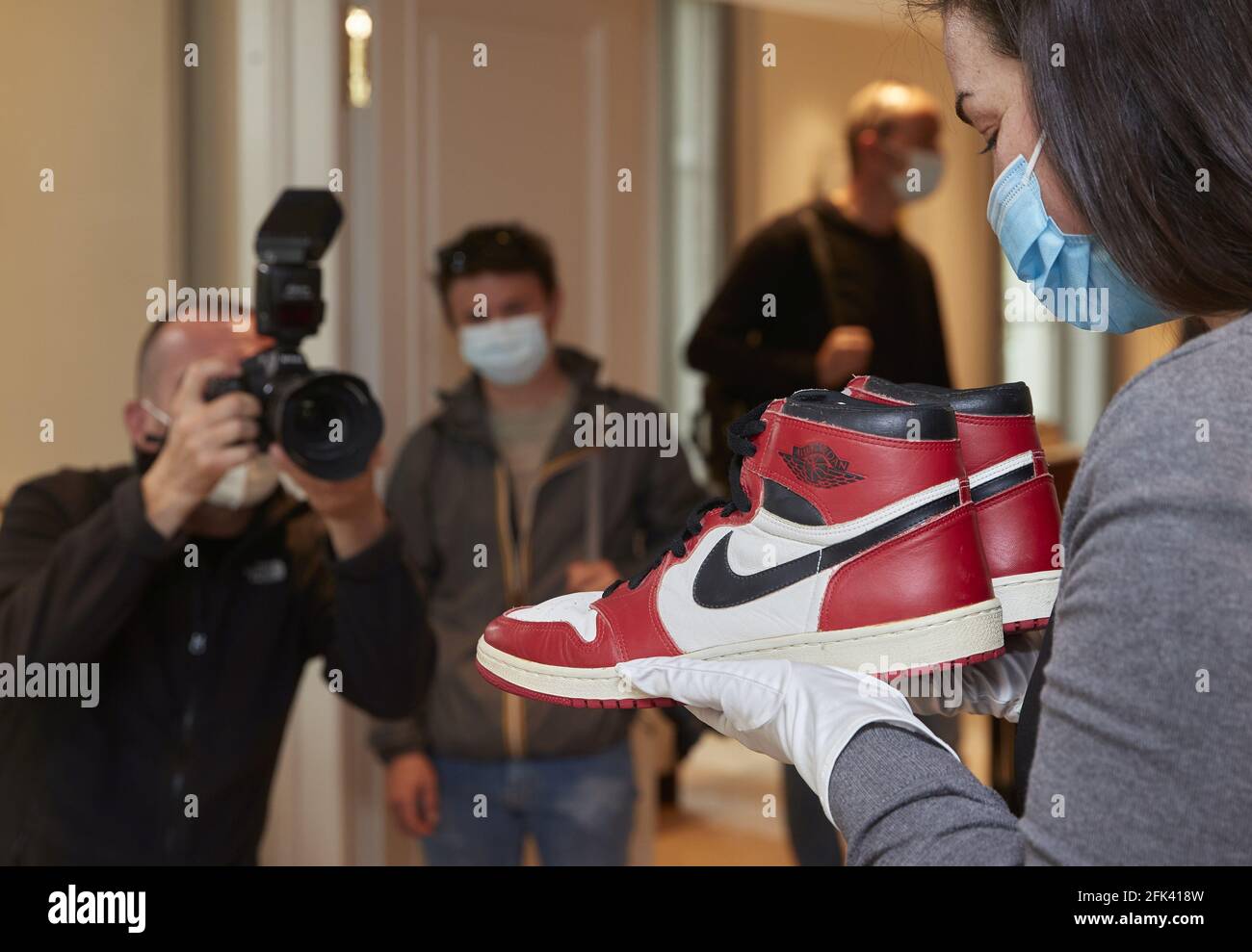 A Sotheby's staff holds a pair of "Air Jordan 1" shoes worn by NBA champion Michael  Jordan during his rookie season in 1984-85 at the Chicago Bulls, during a  preview for the "