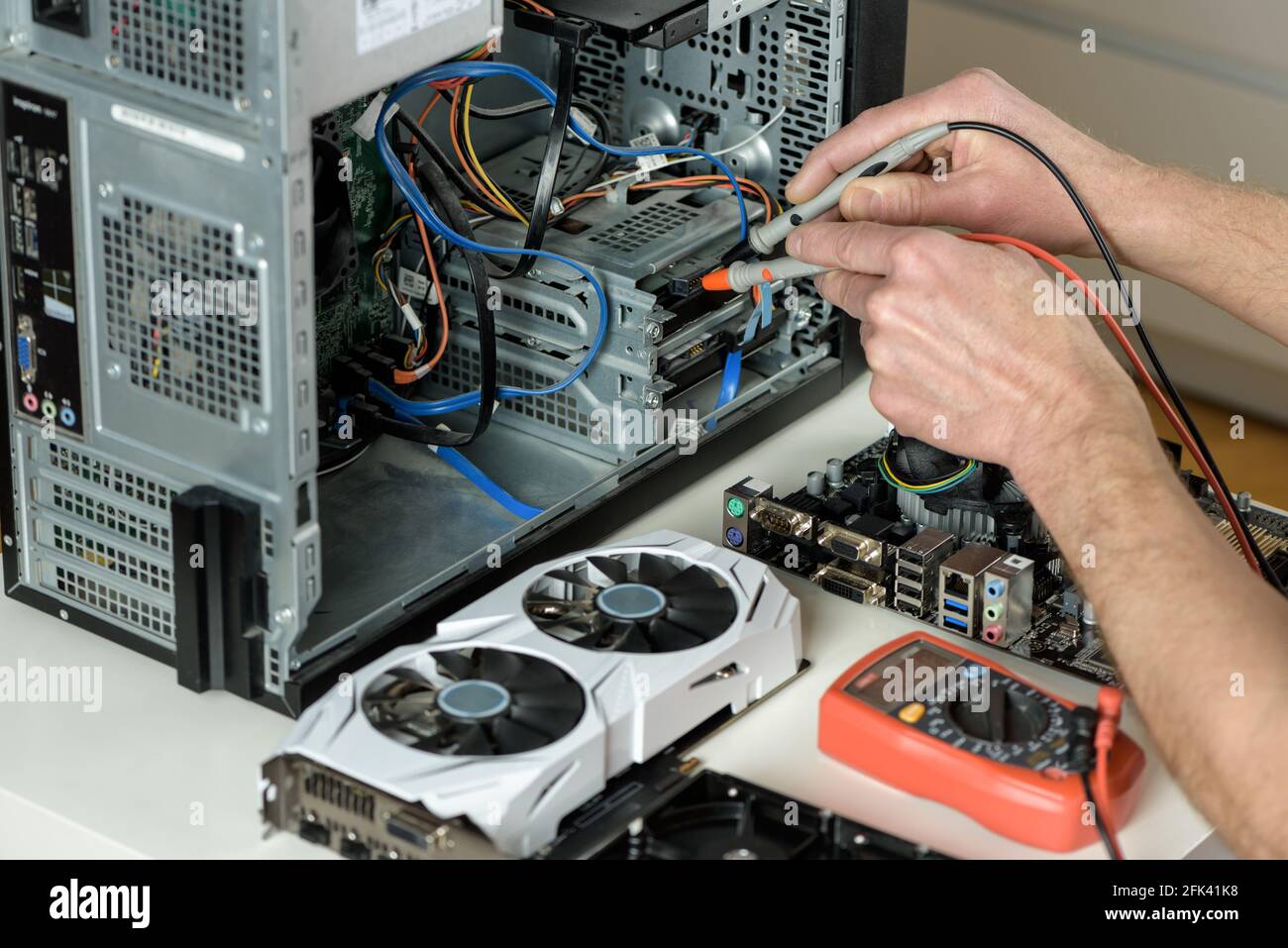 Computer Servising System Multimeter The repairman checks the serviceability of the computer with a ...
