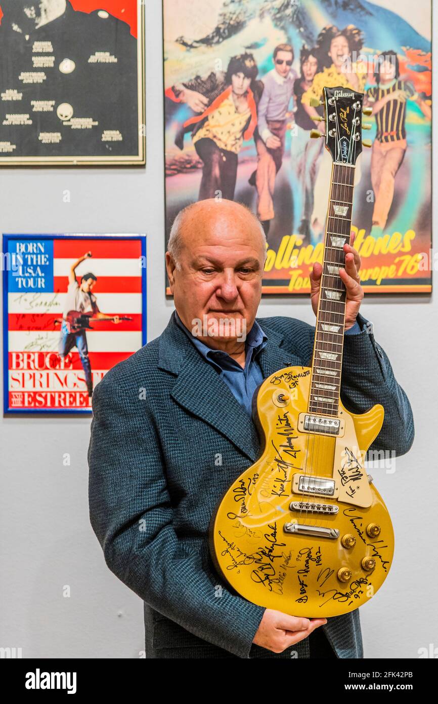 London, UK. 28th Apr, 2021. Harvey Goldsmith with the top lot of the sale, a multi-signed Les Paul Gold Top Guitar (signed at Bob Dylan's The 30th Anniversary Concert), Estimate £10,000-15,000 - Preview of the Harvey Goldsmith collection of entertainment memorabilia at Bonhams, New Bond Street, London. It will be part of the Entertainment Memorabilia sale in the Knightsbridge saleroom on 5 May. His collection is made up of 41 lots, and estimates range from £200-10,000. Credit: Guy Bell/Alamy Live News Stock Photo