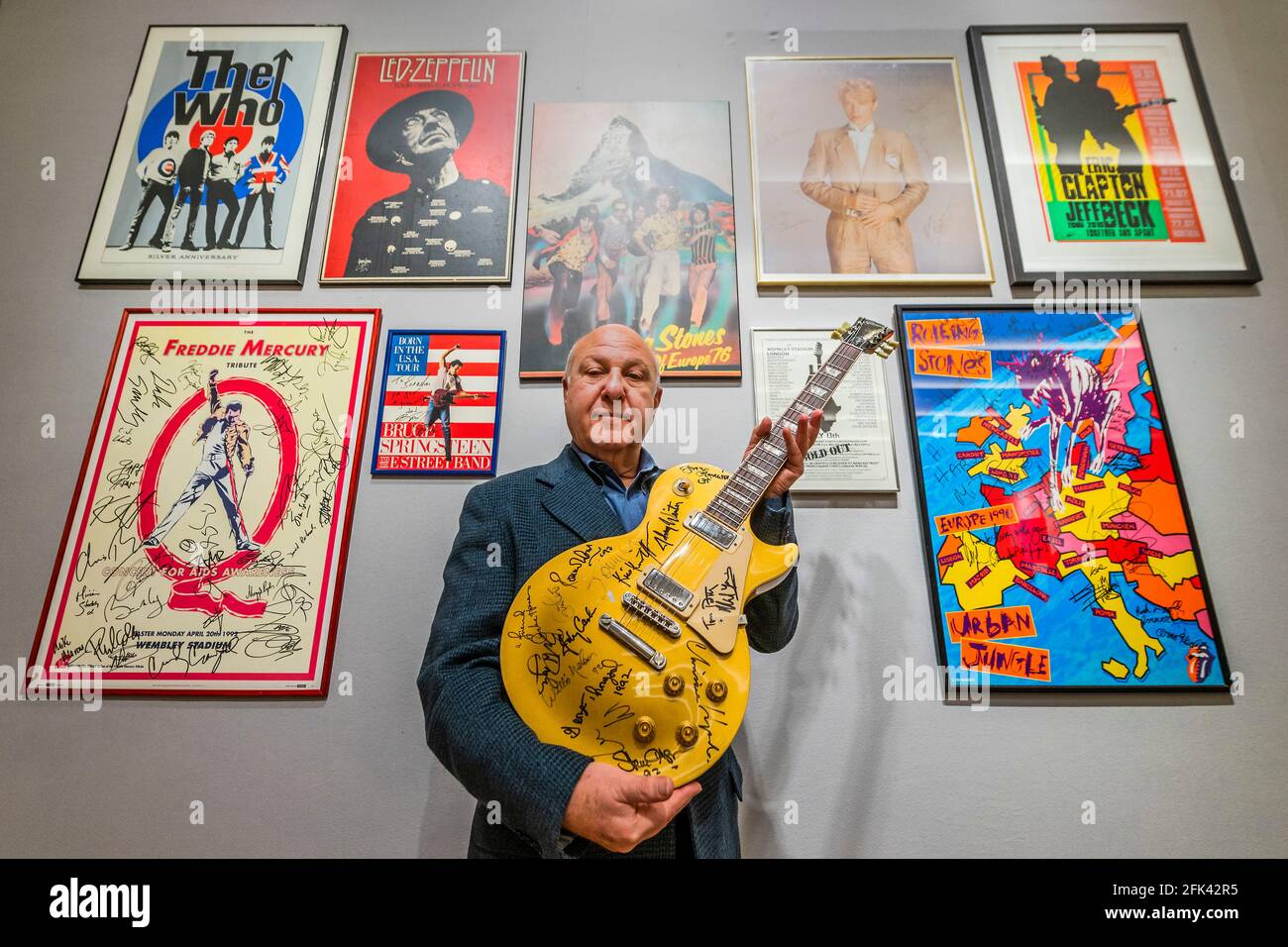 London, UK. 28th Apr, 2021. Harvey Goldsmith with the top lot of the sale, a multi-signed Les Paul Gold Top Guitar (signed at Bob Dylan's The 30th Anniversary Concert), Estimate £10,000-15,000 - Preview of the Harvey Goldsmith collection of entertainment memorabilia at Bonhams, New Bond Street, London. It will be part of the Entertainment Memorabilia sale in the Knightsbridge saleroom on 5 May. His collection is made up of 41 lots, and estimates range from £200-10,000. Credit: Guy Bell/Alamy Live News Stock Photo