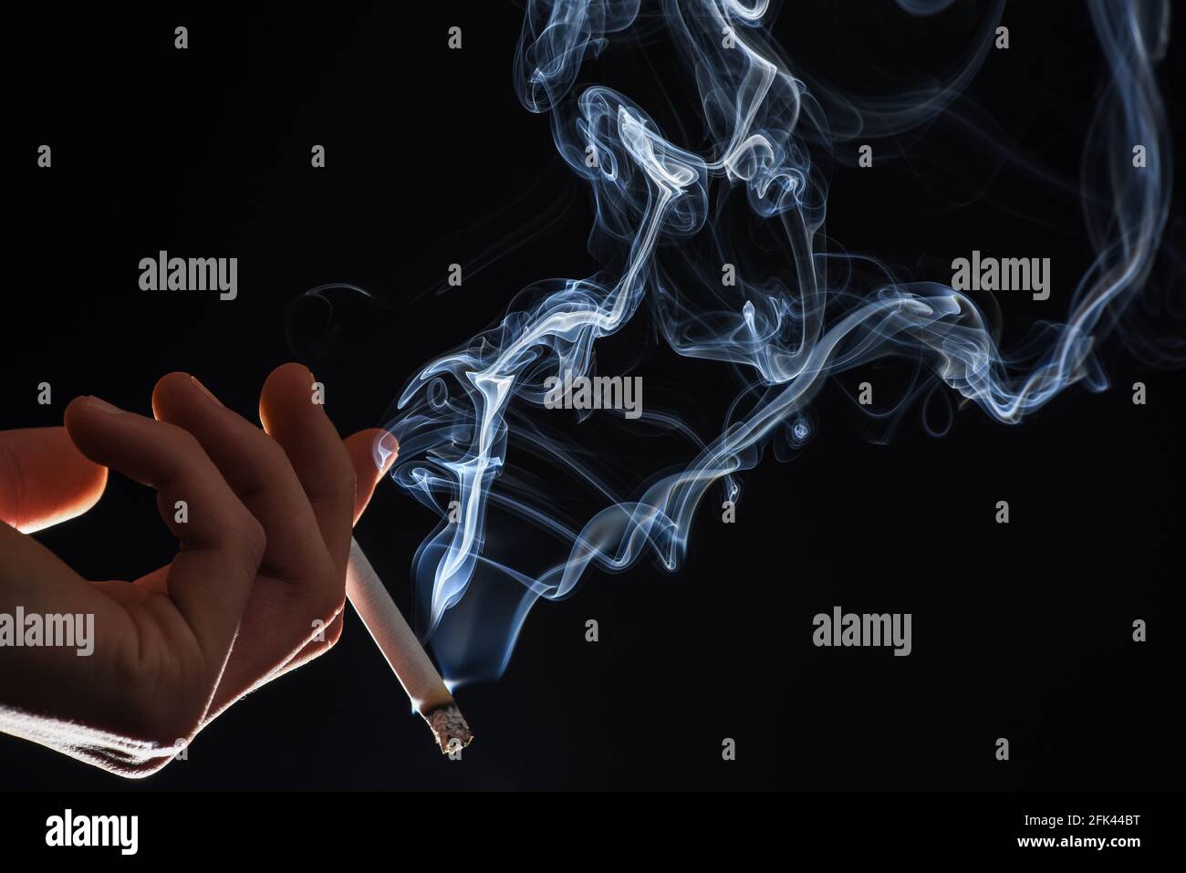 wacko tobacco Tobacco is wacko. Steaming cigarette in male hand. Smoking habit. Tobacco  smoke Stock Photo