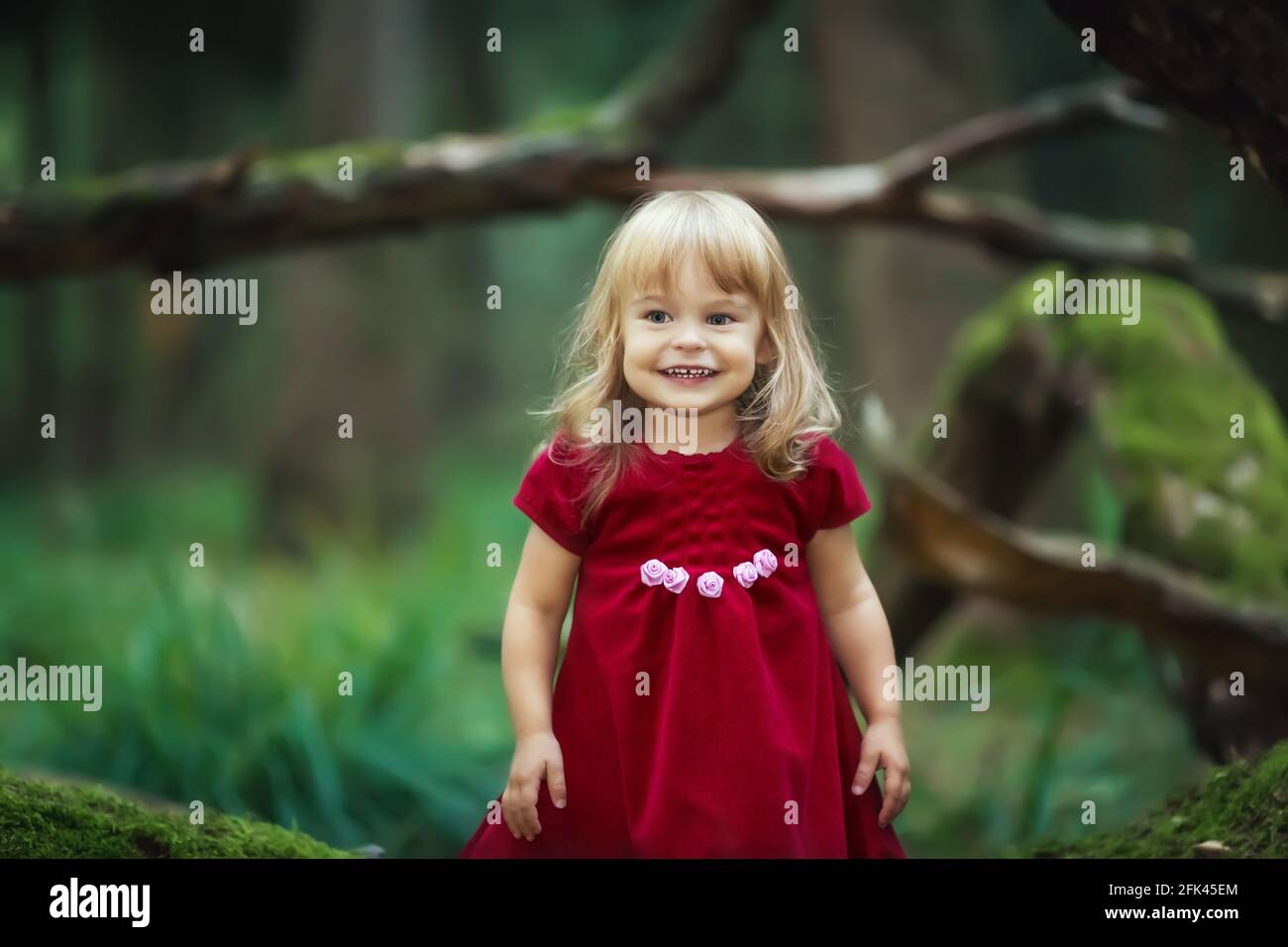 Little girl in the wild green forest Stock Photo - Alamy