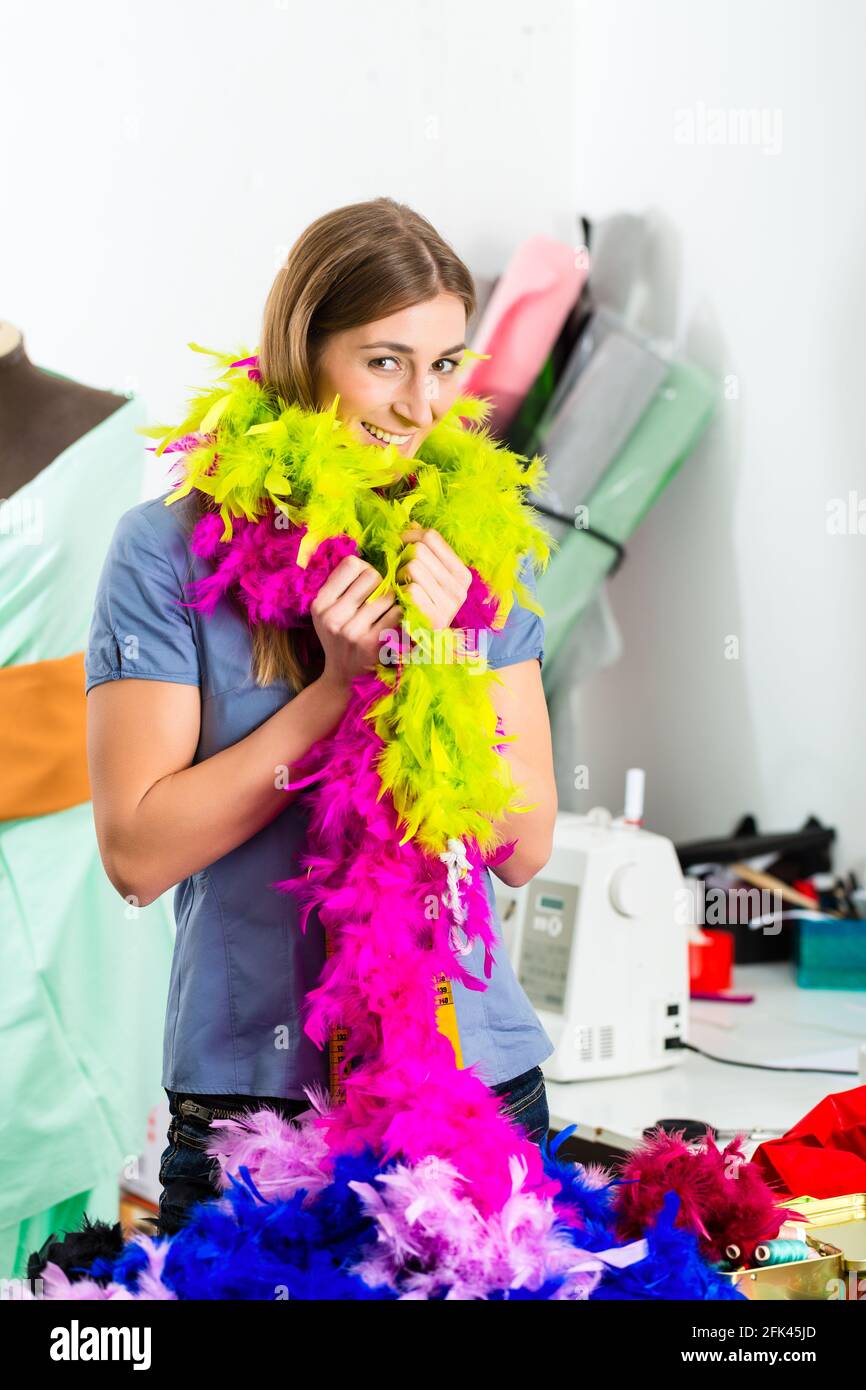 Freelancer - Fashion designer or Tailor working on a design or draft with a feather boa Stock Photo