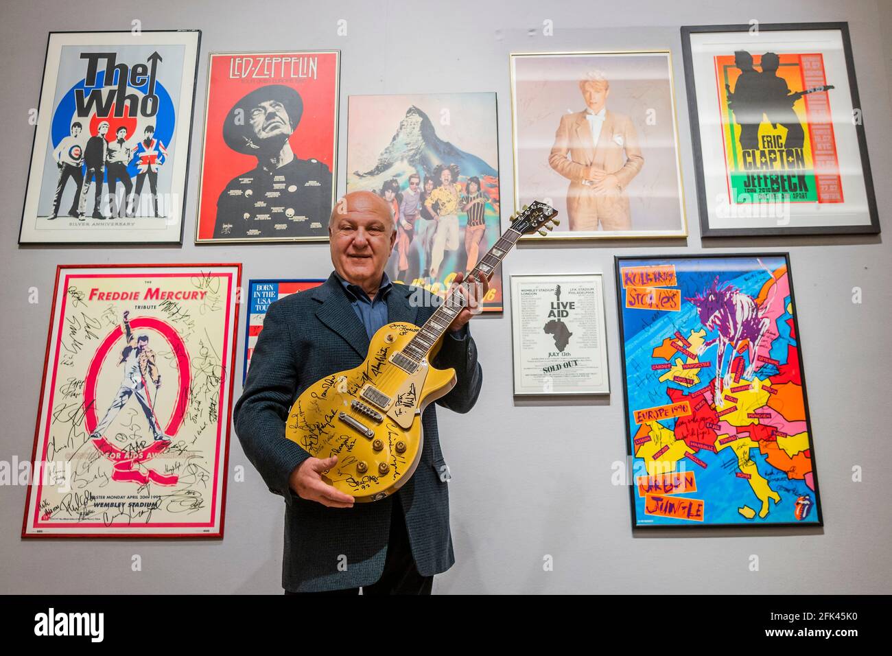 London, UK. 28th Apr, 2021. Harvey Goldsmith with the top lot of the sale, a multi-signed Les Paul Gold Top Guitar (signed at Bob Dylan's The 30th Anniversary Concert), Estimate £10,000-15,000 - Preview of the Harvey Goldsmith collection of entertainment memorabilia at Bonhams, New Bond Street, London. It will be part of the Entertainment Memorabilia sale in the Knightsbridge saleroom on 5 May. His collection is made up of 41 lots, and estimates range from £200-10,000. Credit: Guy Bell/Alamy Live News Stock Photo