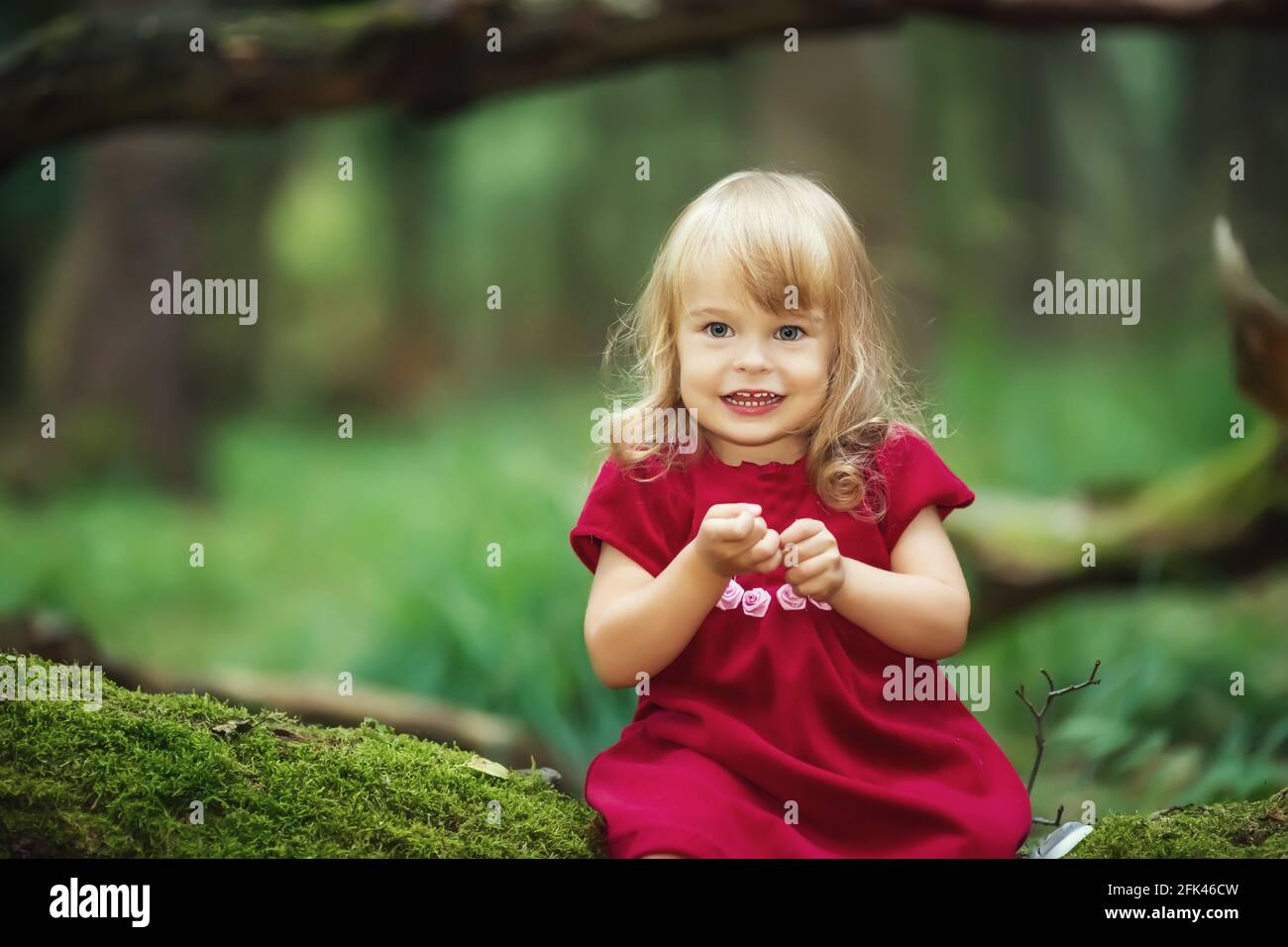 Little girl in the wild green forest Stock Photo - Alamy