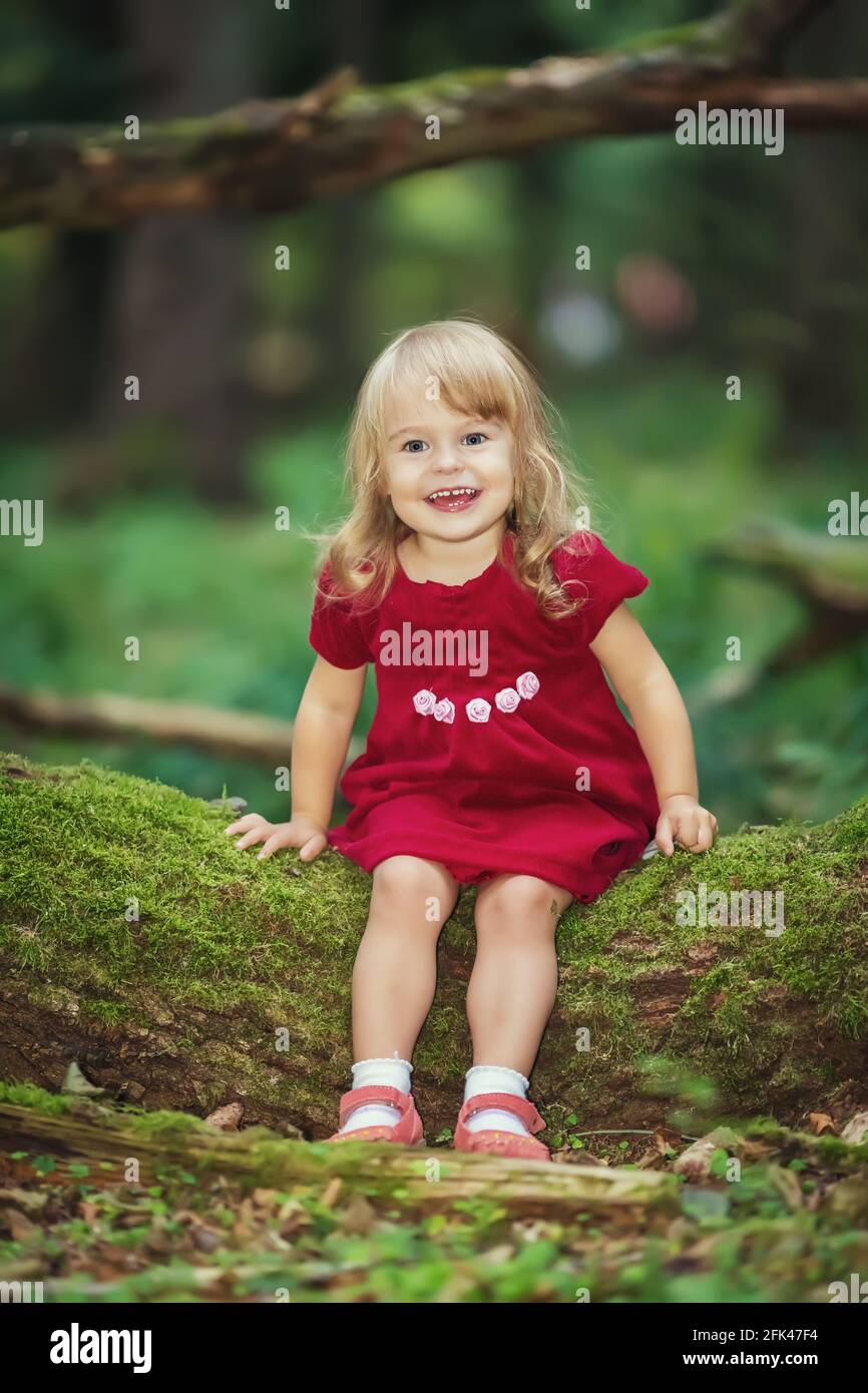 Little girl in the wild green forest Stock Photo - Alamy