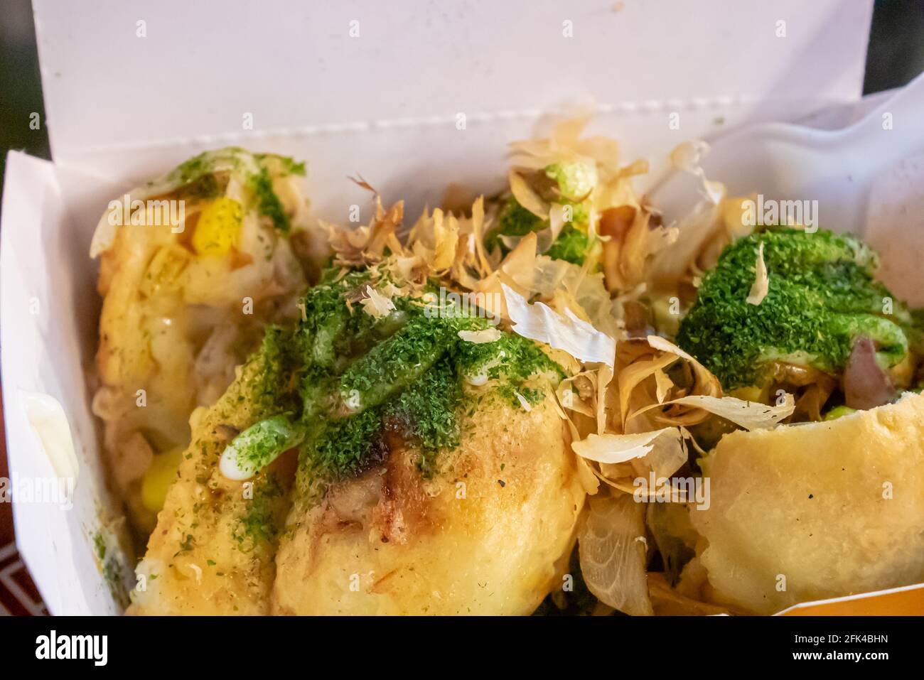 Big takoyaki, a close up of Japanese delicious fried octopus balls food in white paper box at Taipei night market, Taiwan. Stock Photo