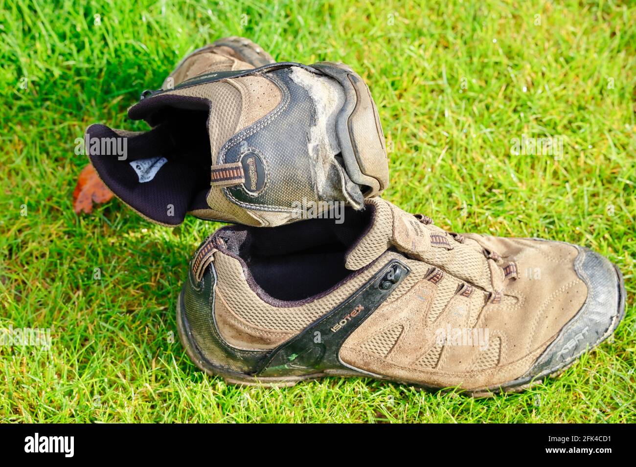 Worn out pair of well used hiking walking shoes, showing the lack of tread on the soles. Stock Photo