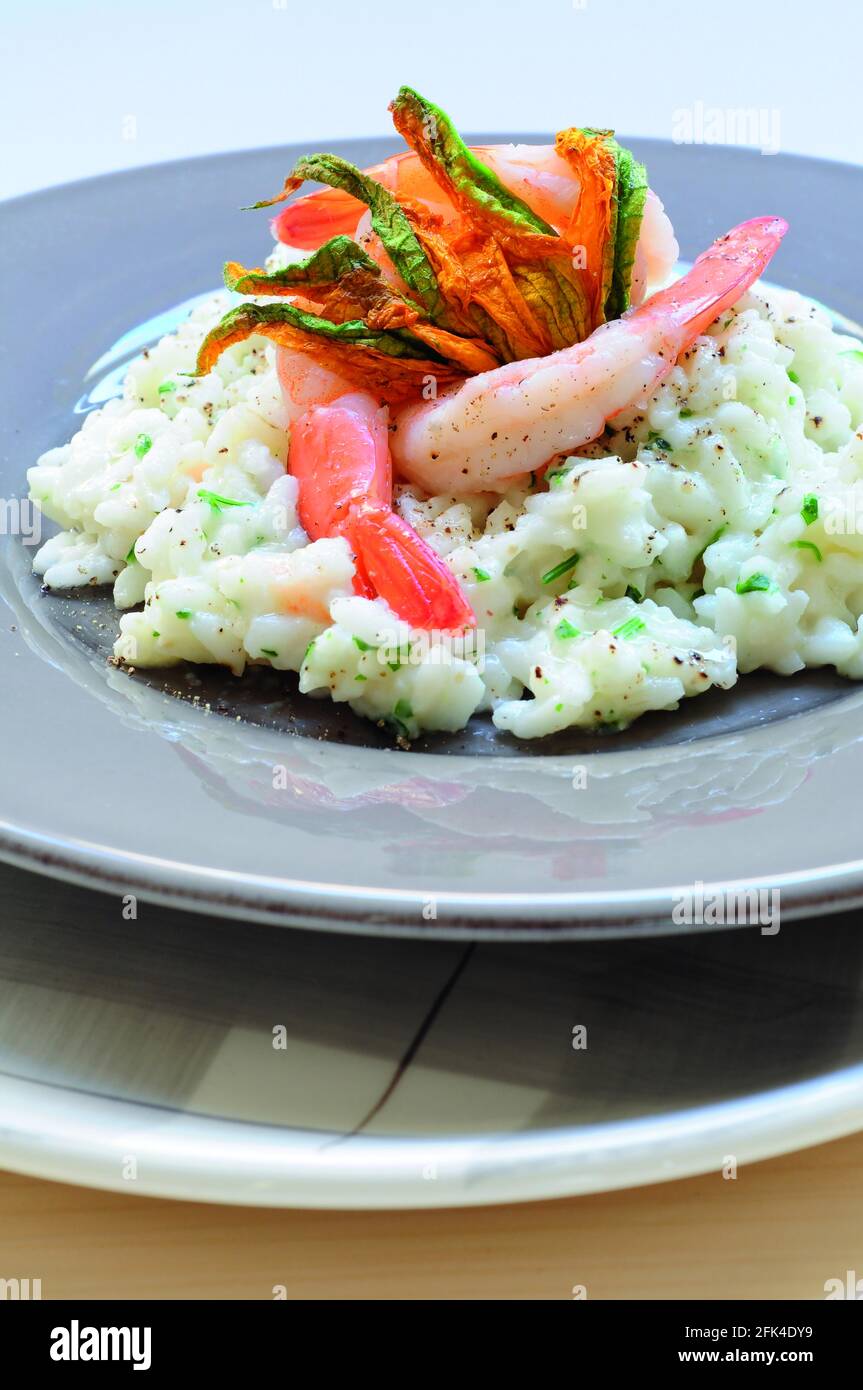 Risotto with scampi and courgette flowers Stock Photo Alamy