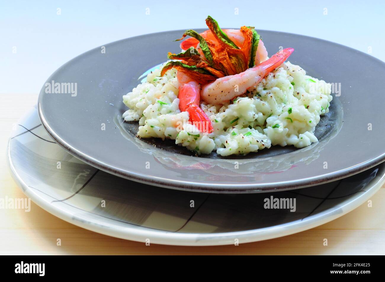 Risotto with scampi and courgette flowers Stock Photo Alamy