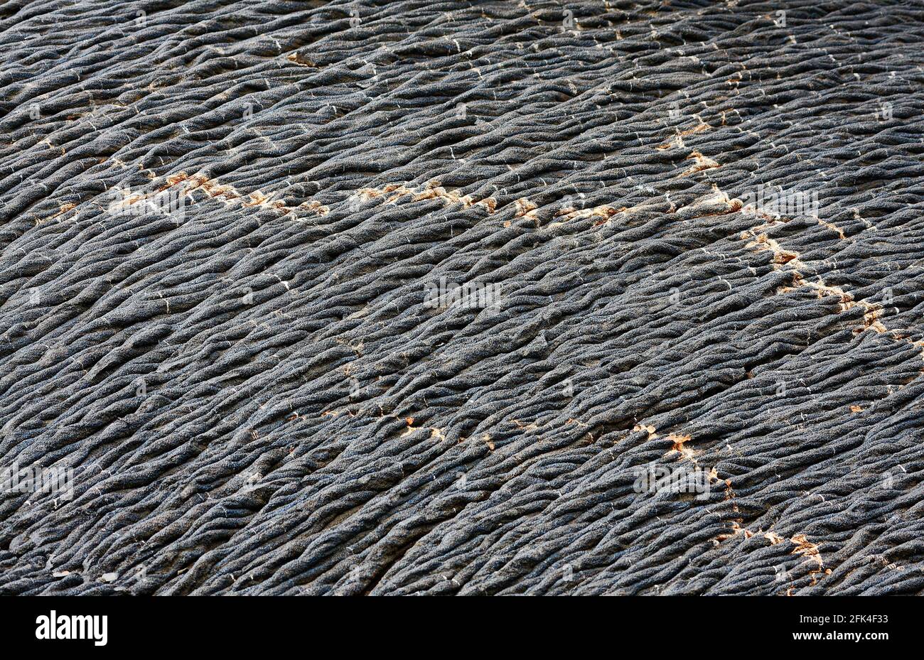 ropey pahoehoe lava, grey shades, colored mineral veins, volcanic flow, basalt, nature, South America, Galapagos Islands; Santiago Island, Ecuador Stock Photo