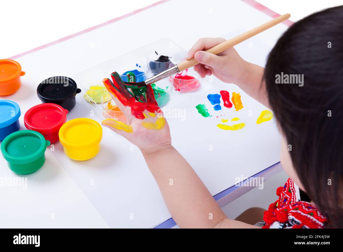 Little asian (thai) girl painting her palm using multicolored